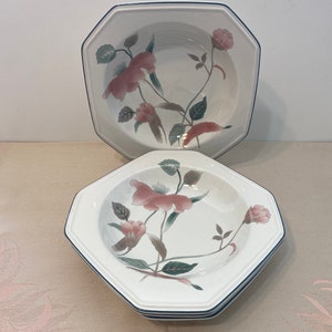 Peut inclure: Ensemble de bols octogonaux blancs avec un motif floral de fleurs roses et de feuilles vertes. Les bols ont une bordure bleu marine. L'image montre une pile de bols et un bol au-dessus.