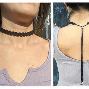 Può includere: Un girocollo nero con un delicato design in pizzo. Il girocollo è regolabile e ha una lunga catena sottile che pende sul retro.