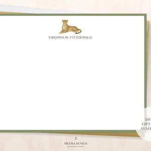 May include: A stationery set featuring a white card with a green border and a gold pen. The card has a cheetah illustration and the name "VIRGINIA W. FITZGERALD" printed in a serif font. The pen is gold.