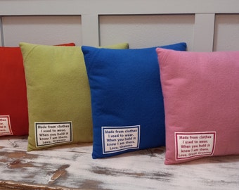 May include: Four square throw pillows in red, green, blue, and pink. Each pillow has a white label with black text that reads "Made from clothes I used to wear. When you hold it know I am there. Love, Great Gramma/Gramma".