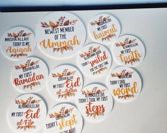 May include: A set of 10 round white stickers with brown and orange floral designs. Each sticker features a different Islamic phrase in gold lettering, such as "Masha Allah Today is my Agigah" and "Subhanallah My First Ramadan".