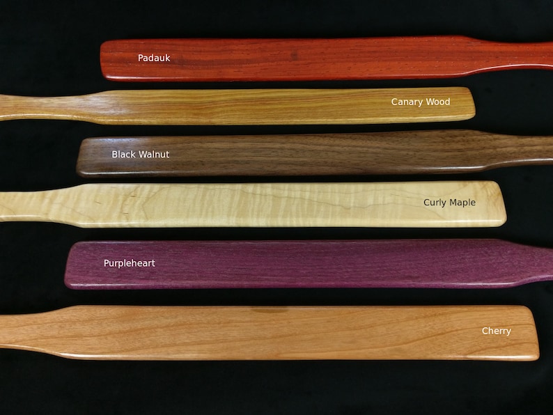 May include: Six wooden paddles in different wood types, including Padauk, Canary Wood, Black Walnut, Curly Maple, Purpleheart, and Cherry.