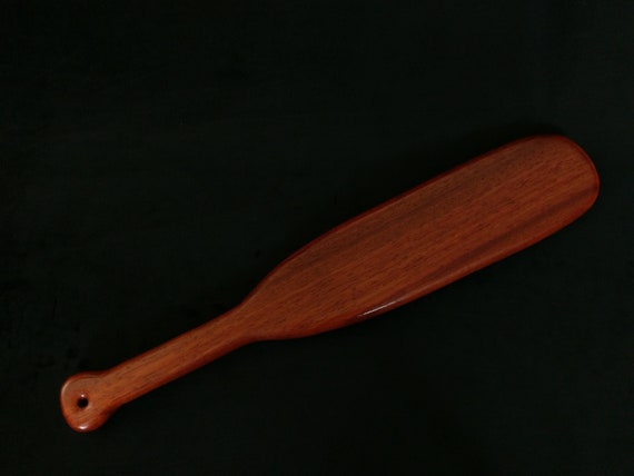 Wooden paddle for spanking on pillow. Domestic discpline