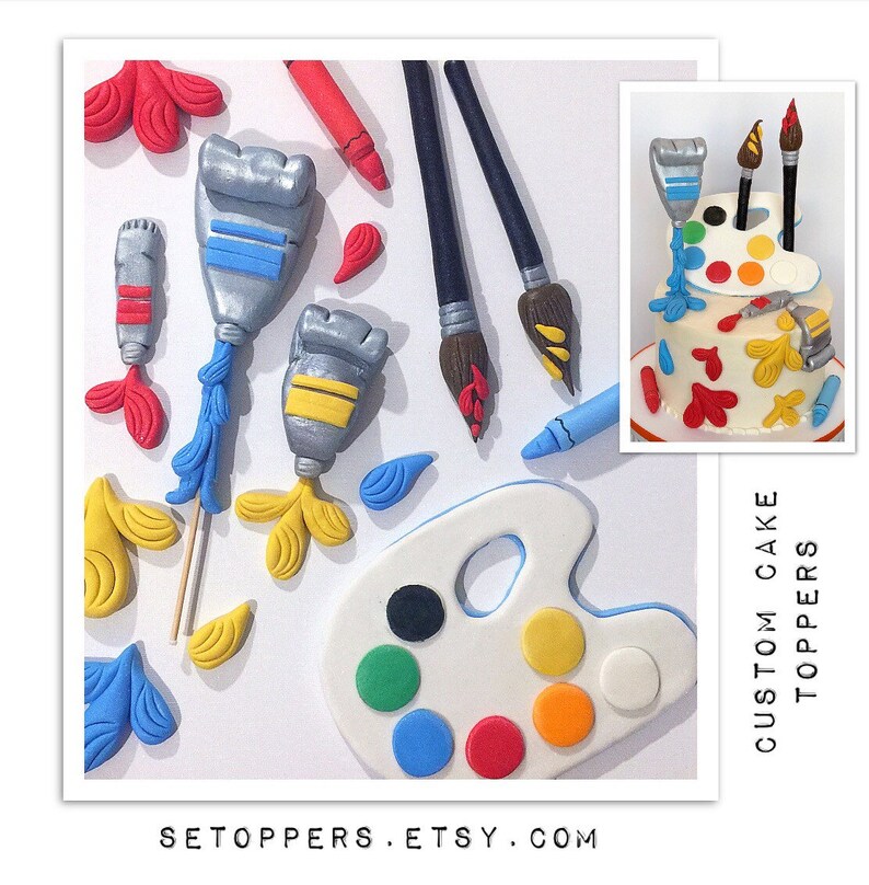May include: Art-themed cake toppers featuring paint tubes, paintbrushes, a crayon, and a palette with colorful paint spots. A small cake with paint-themed decorations is also shown. The text "CUSTOM CAKE TOPPERS" and "SETOPPERS.ETSY.COM" are visible.