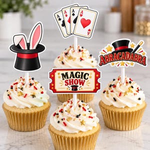 Pode incluir: Um conjunto de quatro topos de cupcake com tema de magia, incluindo uma cartola preta com orelhas de coelho, um leque de quatro cartas de baralho, uma placa vermelha e branca com MAGIC SHOW e uma placa ABRACADABRA com uma varinha mágica.