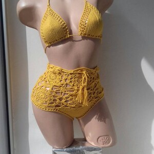 May include: A yellow crochet bikini top and high-waisted bottoms with a tassel detail.