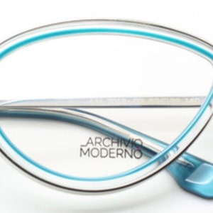 May include: Silver-toned cat-eye glasses with a blue trim around the lenses. The brand name "Archivio Moderno" is printed on the frame.
