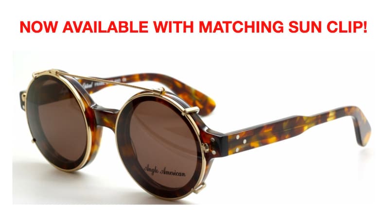 Puede incluir: Gafas de sol redondas de carey con detalles en metal dorado y un parasol de clip. Las gafas de sol tienen lentes marrones y el nombre de la marca "Angle American" est&aacute; impreso en la montura.