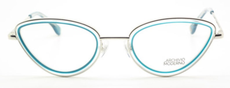 May include: Silver cat-eye glasses with a blue trim and the text "Archivo Moderno" on the right lens.