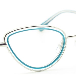May include: Silver cat-eye glasses with a blue trim around the lenses.