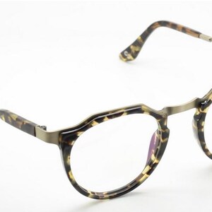 Puede incluir: Gafas redondas con montura y patillas con estampado de carey. Las lentes se sujetan con un fino puente y bisagras met&aacute;licas. Las gafas tienen un dise&ntilde;o cl&aacute;sico y elegante.