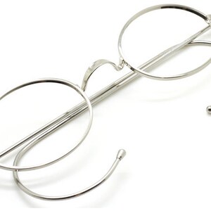 Oval vintage style spectacles in shiny silver with saddlebridge and hooked ear pieces.