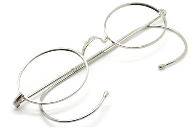 Oval vintage style spectacles in shiny silver with saddlebridge and hooked ear pieces.