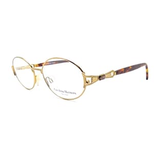 Op de afbeelding: Ovale gouden bril met een schildpadkleurige poot en de tekst "Carolina Herrera" op het montuur.
