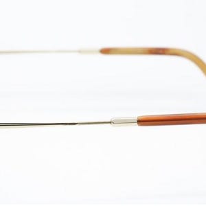 May include: Brown and gold-toned sunglasses with a tortoiseshell pattern on the frames. The arms are a combination of gold metal and brown plastic, with a curved design for a comfortable fit. The lenses are dark.
