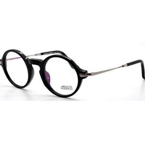 May include: Black round-frame eyeglasses with silver-toned temples. The glasses have a thick, glossy black frame and clear lenses. The brand name "ARCHIVIO MODERNO" is printed on the lower right lens.
