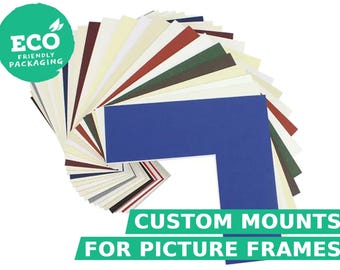 Könnte beinhalten: Ein fächerförmiges Set aus rechteckigen Passepartouts für Bilderrahmen in verschiedenen Farben wie Blau, Rot, Grün, Schwarz, Weiß und Creme. Der Text ECO FRIENDLY PACKAGING und CUSTOM MOUNTS FOR PICTURE FRAMES ist auf dem Bild zu sehen.