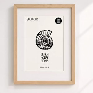 The image is a framed artwork featuring a black and white illustration of a spiral shell or nautilus shell.