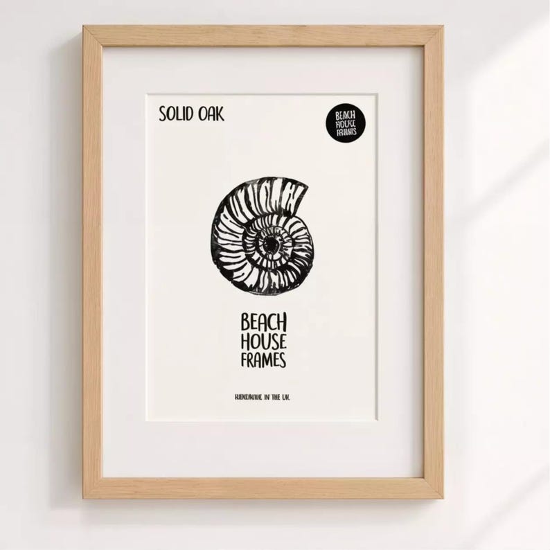 The image is a framed artwork featuring a black and white illustration of a spiral shell or nautilus shell.