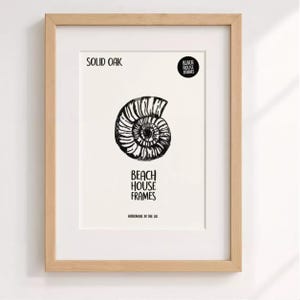 The image is a framed artwork featuring a black and white illustration of a spiral shell or nautilus shell.