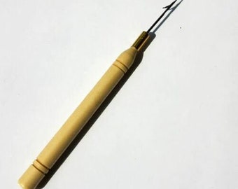 Puede incluir: Un gancho de crochet de madera con un gancho de metal en el extremo. El gancho se utiliza para tejer crochet con hilo.