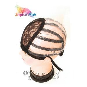 Puede incluir: Una gorra de peluca de encaje negro con un forro de plástico transparente y correas ajustables. La gorra tiene un frente de encaje y una parte posterior tejida.