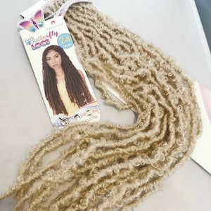 May include: A package of 24 inch long blonde butterfly locs hair extensions. The package has a colorful butterfly logo and the text "Butterfly Locs".
