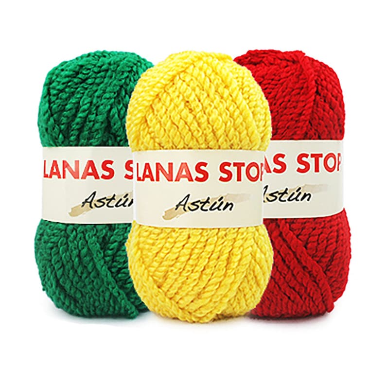 Puede incluir: Tres ovillos de lana en verde, amarillo y rojo. Cada ovillo tiene una etiqueta que dice "LANAS STONAS ASTUIN".
