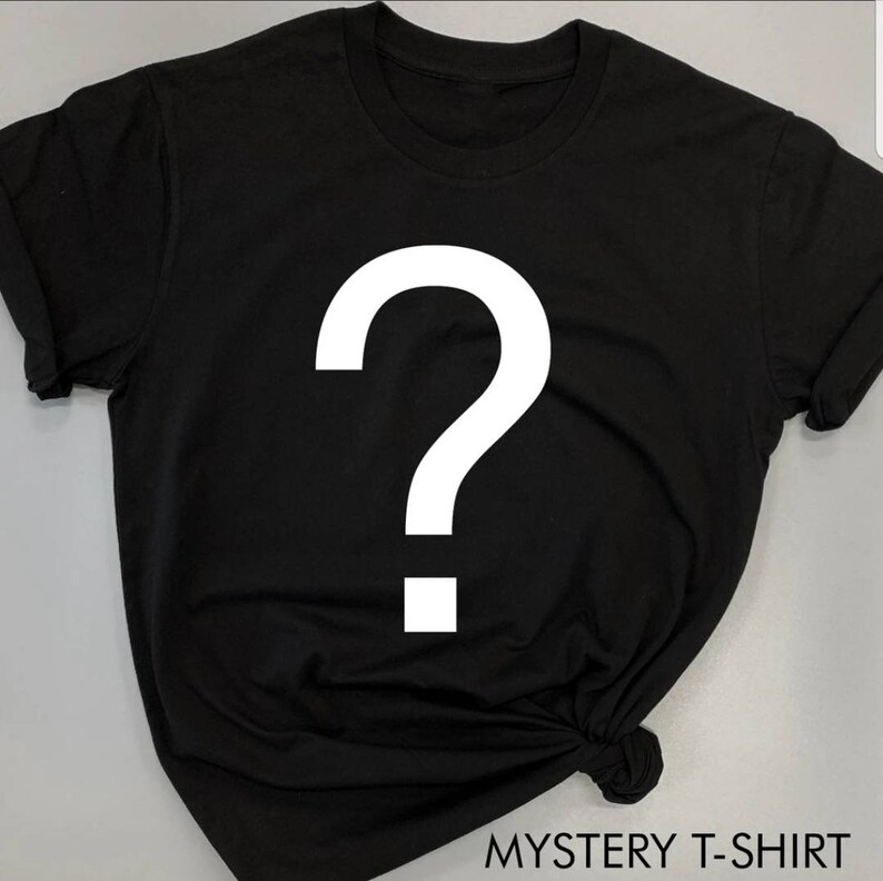K&ouml;nnte beinhalten: Schwarzes T-Shirt mit einem gro&szlig;en wei&szlig;en Fragezeichen auf der Vorderseite. Der Text "MYSTERY T-SHIRT" ist unten im Bild in Wei&szlig; gedruckt. Das T-Shirt hat kurze &Auml;rmel und einen Rundhalsausschnitt.