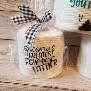 May include: A gift set of white toilet paper rolls wrapped in clear cellophane and tied with a black and white checkered bow. One roll is printed with "World's Greatest Farter Father".