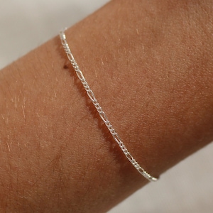 May include: A delicate silver chain bracelet with a simple design.