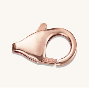 Peut inclure: Fermoir mousqueton en or rose avec mécanisme à ressort. Le fermoir est d'une couleur métallique chaude et a une finition lisse et polie. La conception comprend un corps incurvé avec une ouverture circulaire et un levier pour une fermeture sécurisée.