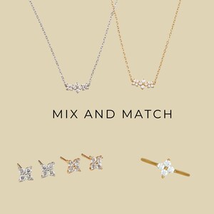 May include: Two delicate necklaces with a cluster of small diamonds, a pair of diamond stud earrings, and a diamond ring. The text "MIX AND MATCH" is displayed below the necklaces.