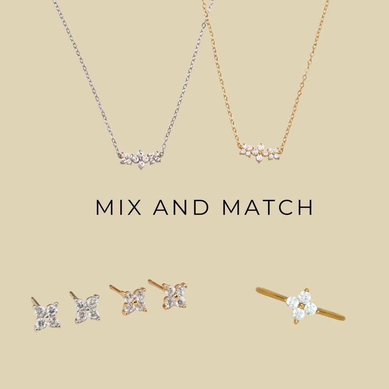 May include: Two delicate necklaces with a cluster of small diamonds, a pair of diamond stud earrings, and a diamond ring. The text "MIX AND MATCH" is displayed below the necklaces.