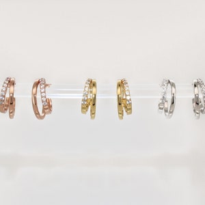 K&ouml;nnte beinhalten: Drei Paar Creolen mit einem Doppelband-Design. Die Ohrringe sind in Ros&eacute;gold, Gold und Silber erh&auml;ltlich.