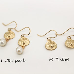 May include: Two pairs of gold earrings with a sand dollar design. The first pair features a pearl dangling below each sand dollar. The second pair is minimal with just the sand dollar design. The text '#1 With pearls' and '#2 Minimal' is below each pair of earrings.