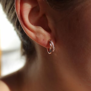 K&ouml;nnte beinhalten: Ohrringe aus Ros&eacute;gold mit einem Reihen von kleinen, klaren Zirkonia-Steinen.