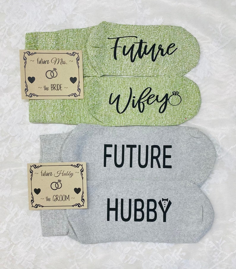 May include: Two pairs of socks with text printed on them. One pair is green with the text "Future Wifey" and the other pair is grey with the text "FUTURE HUBBY".