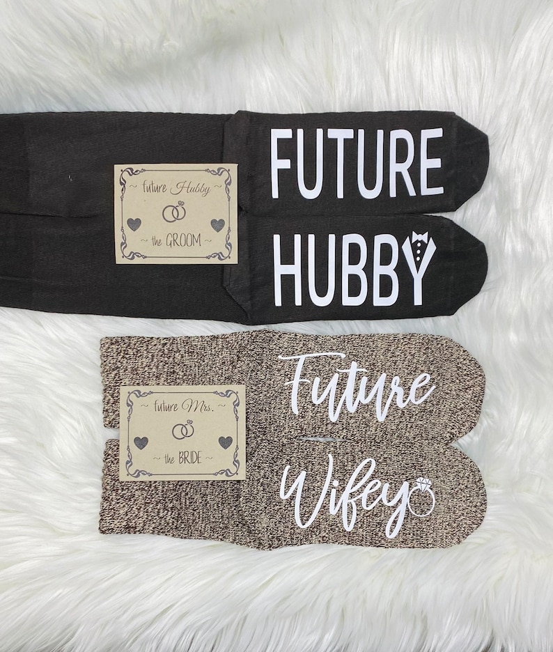 May include: Two pairs of socks with text printed on them. One pair is black with the text "FUTURE HUBBY" and the other pair is brown with the text "Future Wifey".