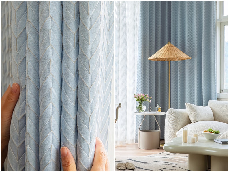 May include: Close-up of light blue curtains with a chevron pattern. The curtains are hung in a living room with a white couch, a side table, and a lamp with a woven shade.