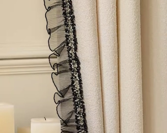 May include: White curtains with a black lace trim. The curtains are hanging in a room with a wooden table and candles.