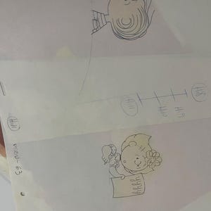 May include: Two black and white pencil drawings of Charlie Brown from the Peanuts comic strip. The top drawing shows Charlie Brown looking up and to the right. The bottom drawing shows Charlie Brown holding a sign that says "Happy Birthday".