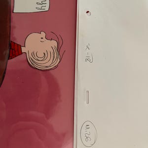 May include: A cartoon illustration of a Peanuts character, Charlie Brown, with a red and white striped shirt, looking to the right. The illustration is on a pink background. The text "hhhh" is written on a piece of paper held by a character in the background.