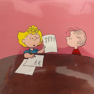 May include: A cartoon illustration of two children sitting at a table, one writing 'yyy' on a piece of paper and the other writing 'hh' on a piece of paper.
