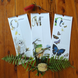 K&ouml;nnte beinhalten: Drei H&auml;ngekalender mit Illustrationen von Tieren und den Monaten Oktober, Mai und November. Jeder Kalender zeigt ein anderes Tier, darunter eine Eule, ein Frosch und ein Schmetterling.
