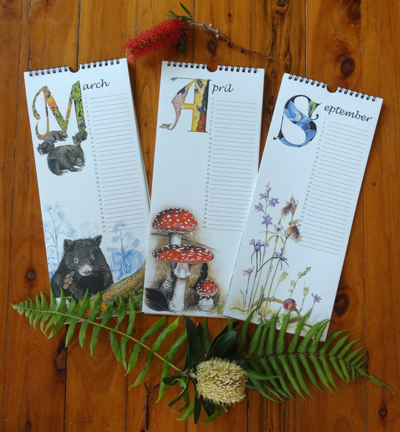 K&ouml;nnte beinhalten: Drei Wandkalender mit bunten Illustrationen von Tieren und Pflanzen. Die Kalender sind f&uuml;r M&auml;rz, April und September. Jeder Kalender hat eine andere Tier- und Pflanzenillustration. Die Kalender befinden sich auf einer Holzoberfl&auml;che.