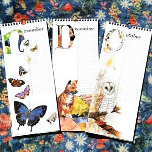 K&ouml;nnte beinhalten: Drei farbenfrohe Kalenderbl&auml;tter mit Illustrationen von Tieren und Natur. Die Seiten sind mit "November", "Dezember" und "Oktober" beschriftet.