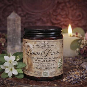 May include: A jar of "Lunar Priestess" organic ritual tea with a black lid and a label featuring an illustration. The label lists ingredients like chamomile and lavender. The image includes a lit candle, flowers, and a crystal.