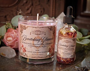 Op de afbeelding: Een roze rituele kaars en een glazen flesje met een druppelaar, beide met het label "Bewitching Glamour". De kaars zit in een helder glas en de fles bevat rozenblaadjes.