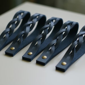 May include: Five dark blue leather drawer pulls with a braided design and gold metal accents.